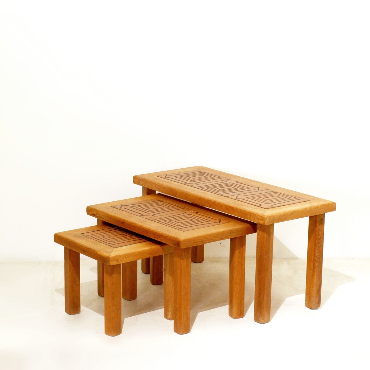 Brutalist solid oak nesting tables with geometric-patterned tiles