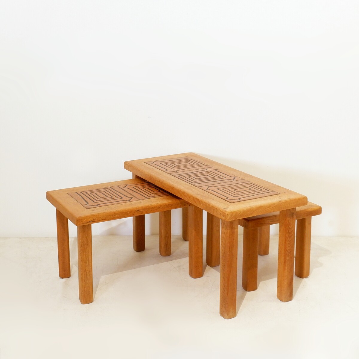Brutalist solid oak nesting tables with geometric-patterned tiles