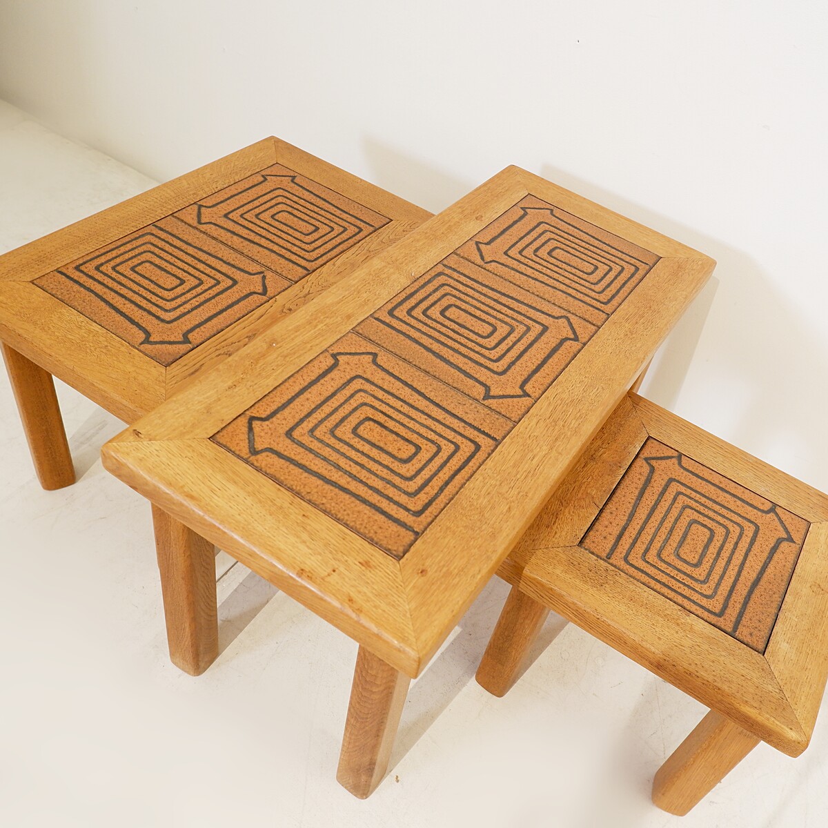 Brutalist solid oak nesting tables with geometric-patterned tiles
