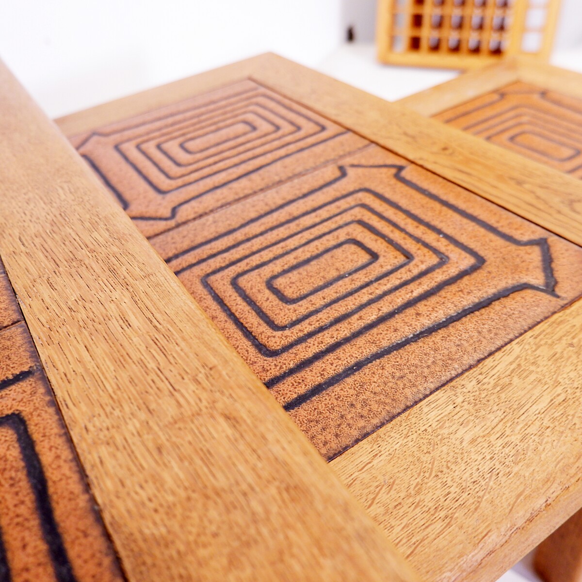 Brutalist solid oak nesting tables with geometric-patterned tiles