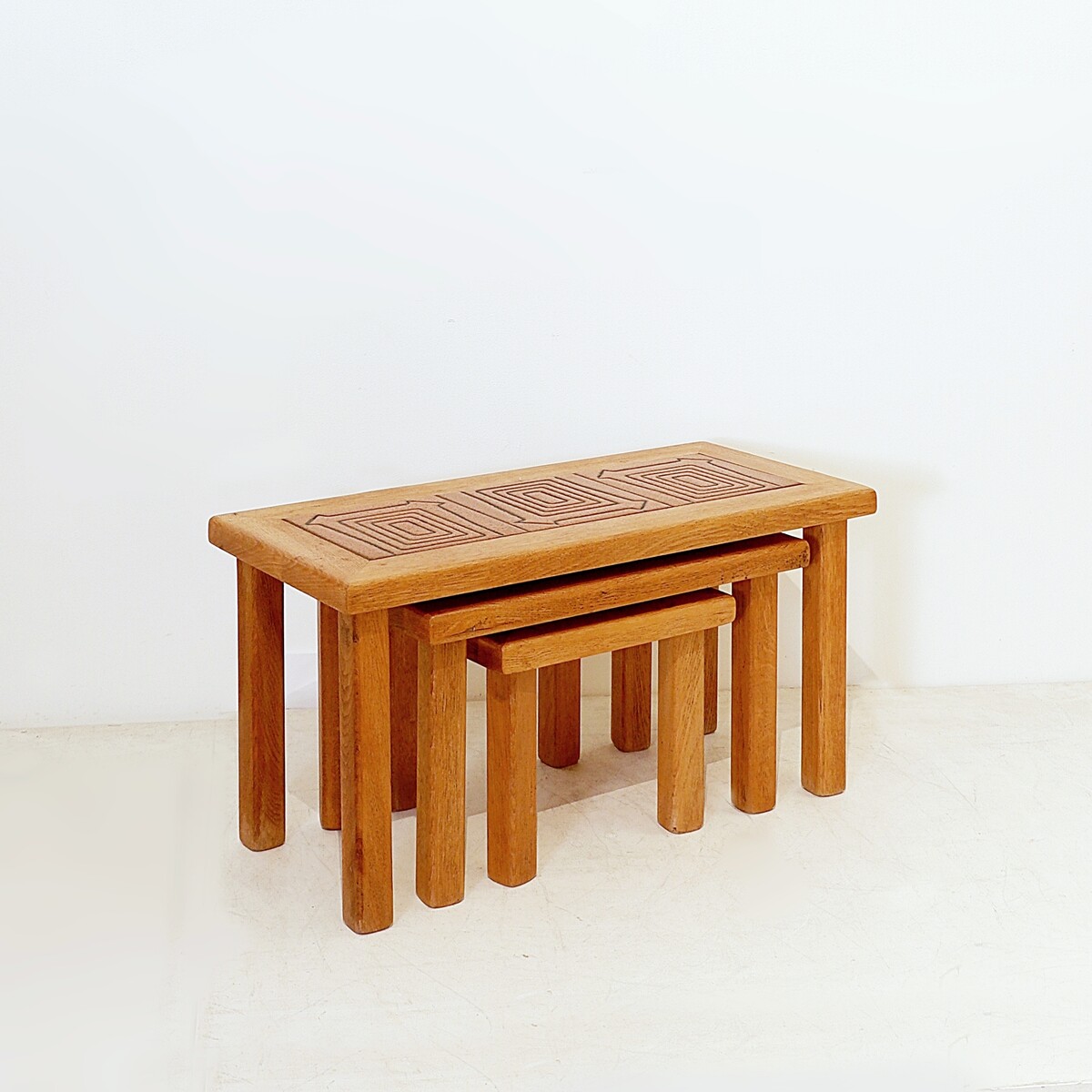 Brutalist solid oak nesting tables with geometric-patterned tiles