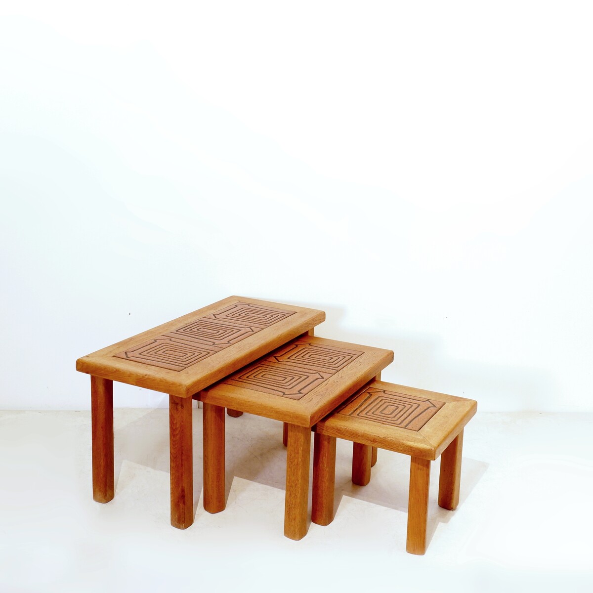 Brutalist solid oak nesting tables with geometric-patterned tiles