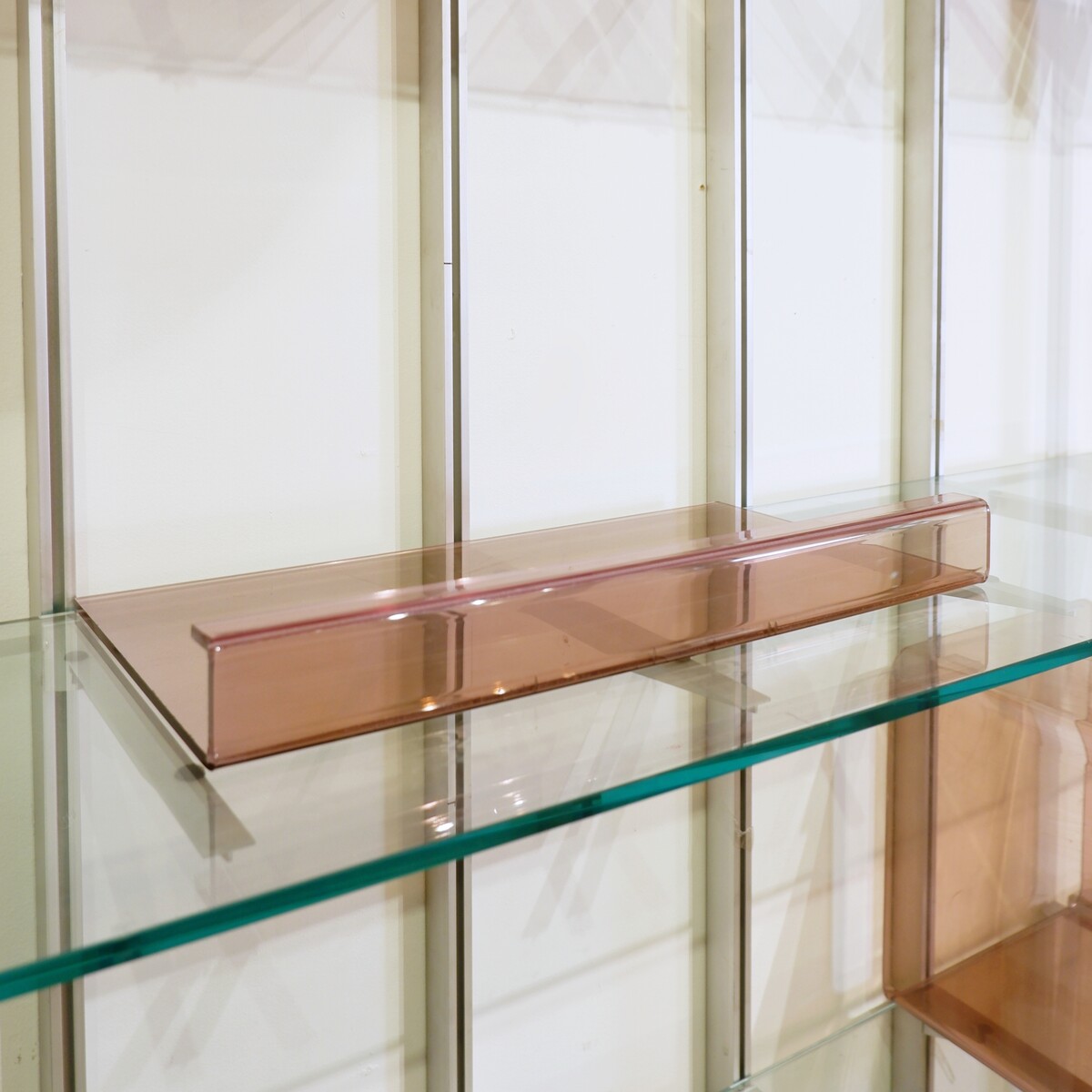 Modular wall shelf in brushed metal, glass and acrylic, in the style of Michel Ducaroy