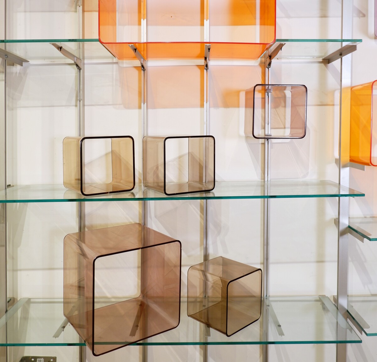 Modular wall shelf in brushed metal, glass and acrylic, in the style of Michel Ducaroy