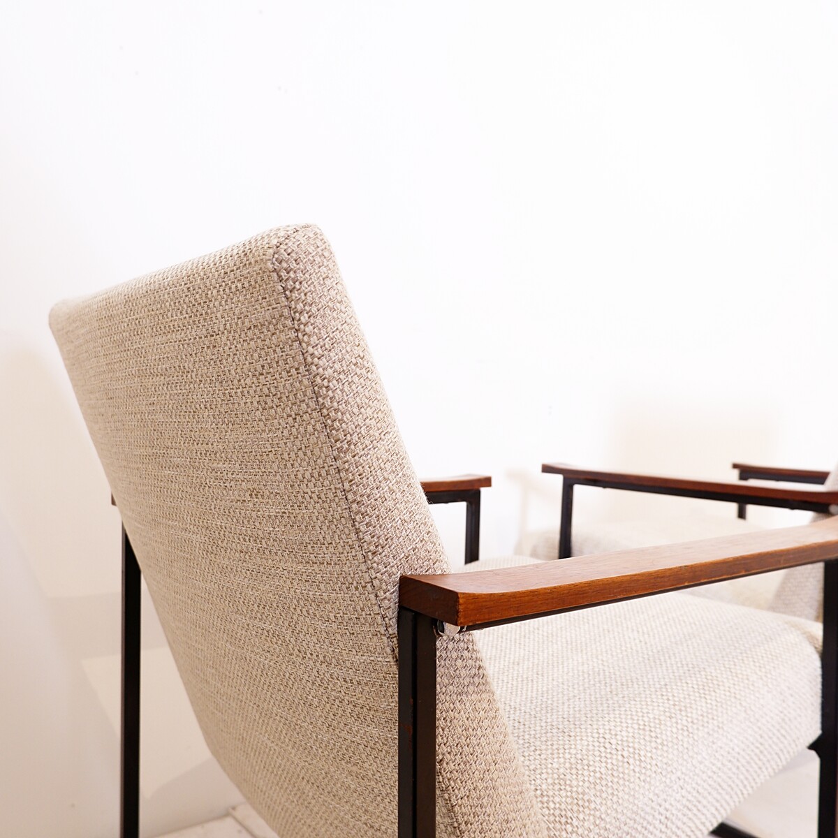 Pair of mid-century armchairs with black metal frames and wooden armrests - New Upholstery